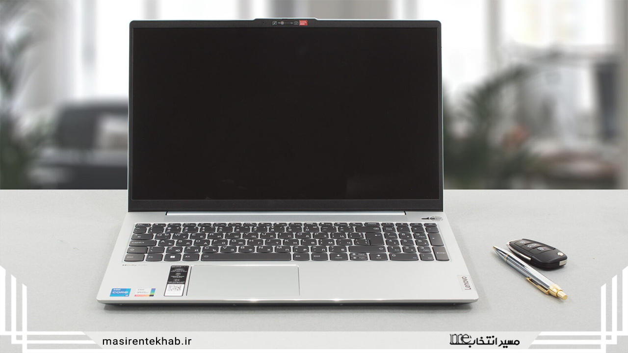 یک لپ‌تاپ لنوو ایدیاپد 5 با صفحه‌نمایش 15.6 اینچی روی یک میز قرار گرفته است. یک قلم و یک کنترل ماشین در کنار لپ‌تاپ دیده می‌شوند.
